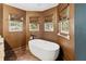 A luxurious bathtub sits beneath three windows, enhancing the bathroom's elegant design at 2306 63Rd W St # 40, Bradenton, FL 34209