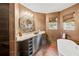 Elegant bathroom with a granite vanity, unique mirror, and a luxurious standalone tub at 2306 63Rd W St # 40, Bradenton, FL 34209