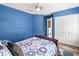 Bright blue bedroom boasts modern ceiling fan, patterned bedding, and ample closet space at 2306 63Rd W St # 40, Bradenton, FL 34209
