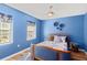 A blue bedroom offers a serene ambiance and includes matching decor accents and a ceiling fan at 2306 63Rd W St # 40, Bradenton, FL 34209