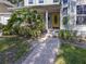 Inviting front entrance with brick walkway and lush landscaping leading to a bright yellow door at 2306 63Rd W St # 40, Bradenton, FL 34209