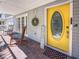 Cozy front porch with rocking chairs, a 'Welcome' sign, and a vibrant yellow door at 2306 63Rd W St # 40, Bradenton, FL 34209