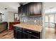Gourmet kitchen features black cabinets, granite countertops, mosaic tile backsplash, and wood-look tile flooring at 2306 63Rd W St # 40, Bradenton, FL 34209