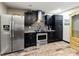 Modern kitchen featuring stainless steel refrigerator, sleek black cabinetry, and stylish mosaic backsplash at 2306 63Rd W St # 40, Bradenton, FL 34209