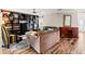 Open-concept living room boasts hardwood floors and custom built-in shelving with a ceiling fan at 2306 63Rd W St # 40, Bradenton, FL 34209