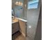 Modern bathroom with a glass-enclosed shower, river rock floor and vanity with bright lighting at 24779 Buckingham Way, Port Charlotte, FL 33980