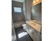 Clean bathroom featuring a tub, single sink vanity with bright lighting and gray tile flooring at 24779 Buckingham Way, Port Charlotte, FL 33980