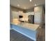 Well-lit kitchen featuring white cabinetry, stainless steel appliances, and a quartz countertop bar at 24779 Buckingham Way, Port Charlotte, FL 33980