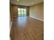 Bright living room featuring neutral walls, wood-look tile floors, and sliding glass doors at 24779 Buckingham Way, Port Charlotte, FL 33980
