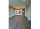 Open-concept space with wood-look flooring, flowing into the kitchen with a breakfast bar at 24779 Buckingham Way, Port Charlotte, FL 33980