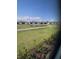 Scenic view featuring lush greenery, a pond and surrounding houses from this home's window at 24779 Buckingham Way, Port Charlotte, FL 33980