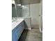 Modern bathroom featuring walk-in shower with glass partition and double sink vanity at 24831 Buckingham Way, Port Charlotte, FL 33980