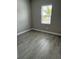Cozy bedroom with wood-look tile flooring and a bright window at 24831 Buckingham Way, Port Charlotte, FL 33980