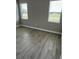 Neutral bedroom showing two windows, base trim, and wood-look tile flooring at 24831 Buckingham Way, Port Charlotte, FL 33980