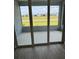 View from inside the living area to the patio and backyard through sliding glass doors at 24831 Buckingham Way, Port Charlotte, FL 33980