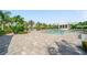Beautiful community pool area with tropical landscaping, lounge seating, and clear blue water at 2625 Star Apple Way, Sarasota, FL 34240