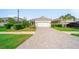 Well-maintained single-story home with a paver driveway and lush landscaping at 2625 Star Apple Way, Sarasota, FL 34240