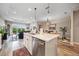 Bright open concept showcasing kitchen island with sink, seamlessly connecting to living & dining areas at 2625 Star Apple Way, Sarasota, FL 34240