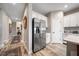 Hallway view leading to the kitchen area, featuring stainless steel refrigerator and white cabinets at 2625 Star Apple Way, Sarasota, FL 34240