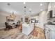 Bright kitchen with white cabinets, an island, stainless steel appliances, and an adjacent dining area at 2625 Star Apple Way, Sarasota, FL 34240