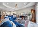 Open-concept living room with a blue sofa, a ceiling fan, and an adjacent kitchen at 2625 Star Apple Way, Sarasota, FL 34240