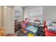 Bright play room with toy kitchen set, dollhouse, and red couch at 2625 Star Apple Way, Sarasota, FL 34240