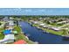 An aerial view shows a canal with a home with boat dock, lift, and a screened in porch at 264 E Tarpon Nw Blvd, Port Charlotte, FL 33952