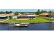 This is the waterfront backyard showing a private dock and screened-in lanai, enhancing the outdoor living space at 264 E Tarpon Nw Blvd, Port Charlotte, FL 33952