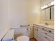 A bathroom with toilet, handrail, single vanity, and bright overhead lighting at 264 E Tarpon Nw Blvd, Port Charlotte, FL 33952