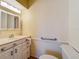 A bathroom with a white vanity, medicine cabinet, toilet and towel bar at 264 E Tarpon Nw Blvd, Port Charlotte, FL 33952