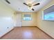 Empty bedroom with ceiling fan, laminate floors, and a window providing ample natural light at 264 E Tarpon Nw Blvd, Port Charlotte, FL 33952