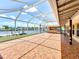 Expansive covered patio featuring brick pavers, an outdoor kitchen, and a picturesque waterfront view at 264 E Tarpon Nw Blvd, Port Charlotte, FL 33952
