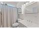 Bright bathroom with a white vanity, patterned shower curtain, and plenty of storage at 318 39Th Ne St, Bradenton, FL 34208