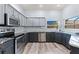 Modern kitchen with gray cabinets, stainless steel appliances, granite countertops, and a bright window at 318 39Th Ne St, Bradenton, FL 34208