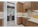 Butler's pantry and bar with marble counters, patterned backsplash, custom cabinets, and stainless steel refrigerator at 3212 Signet Ct, Sarasota, FL 34240