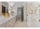 Hallway view of the expansive bathroom featuring a marble tile shower and dual vanity at 3212 Signet Ct, Sarasota, FL 34240