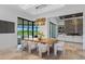 Open concept dining room with luxury finishes and view of outdoor swimming pool and manicured green space at 3212 Signet Ct, Sarasota, FL 34240