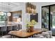This dining room features a wooden table, an elegant chandelier, and a modern kitchen in the background at 3212 Signet Ct, Sarasota, FL 34240