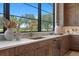 Close up of kitchen featuring marble countertops, custom cabinetry, stylish faucet and outdoor view at 3212 Signet Ct, Sarasota, FL 34240