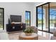 A contemporary living room featuring black framed windows and door showcasing the pool and outdoor living area at 3212 Signet Ct, Sarasota, FL 34240