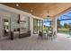 Outdoor covered patio area complete with a summer kitchen, dining area, and views of the landscaped backyard and golf course at 3212 Signet Ct, Sarasota, FL 34240