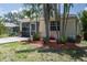 Back exterior view featuring tropical landscaping and a glimpse of the cozy screened patio at 3411 15Th E St, Ellenton, FL 34222
