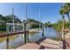 View of the boat lift on the waterway with the surrounding palm trees and shrubbery at 3415 Knox Ter, Port Charlotte, FL 33948