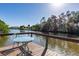 Scenic dock with a patio table overlooking the peaceful waterway and lush greenery at 3415 Knox Ter, Port Charlotte, FL 33948