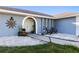 Charming single Gathering home with lush tropical landscaping and a beautiful arched doorway entrance at 3415 Knox Ter, Port Charlotte, FL 33948
