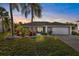 Charming home features a well manicured lawn, tropical landscaping and an attached two car garage at 3415 Knox Ter, Port Charlotte, FL 33948