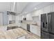 Modern kitchen features white cabinets, stainless steel appliances and an island with cooktop at 3415 Knox Ter, Port Charlotte, FL 33948
