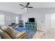 Bright living room with wood floors, media center, and a vaulted ceiling with ceiling fan at 3415 Knox Ter, Port Charlotte, FL 33948