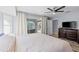 Large primary bedroom boasts natural light, hardwood floors, and sliding glass doors to the pool at 3415 Knox Ter, Port Charlotte, FL 33948