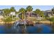 Canal front single Gathering home with a dock, lush tropical landscaping, and a screened in patio at 3415 Knox Ter, Port Charlotte, FL 33948